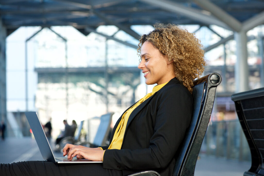 Femme professionnelle travaillant sur son ordinateur portable dans une gare avec Wi-Fi public
